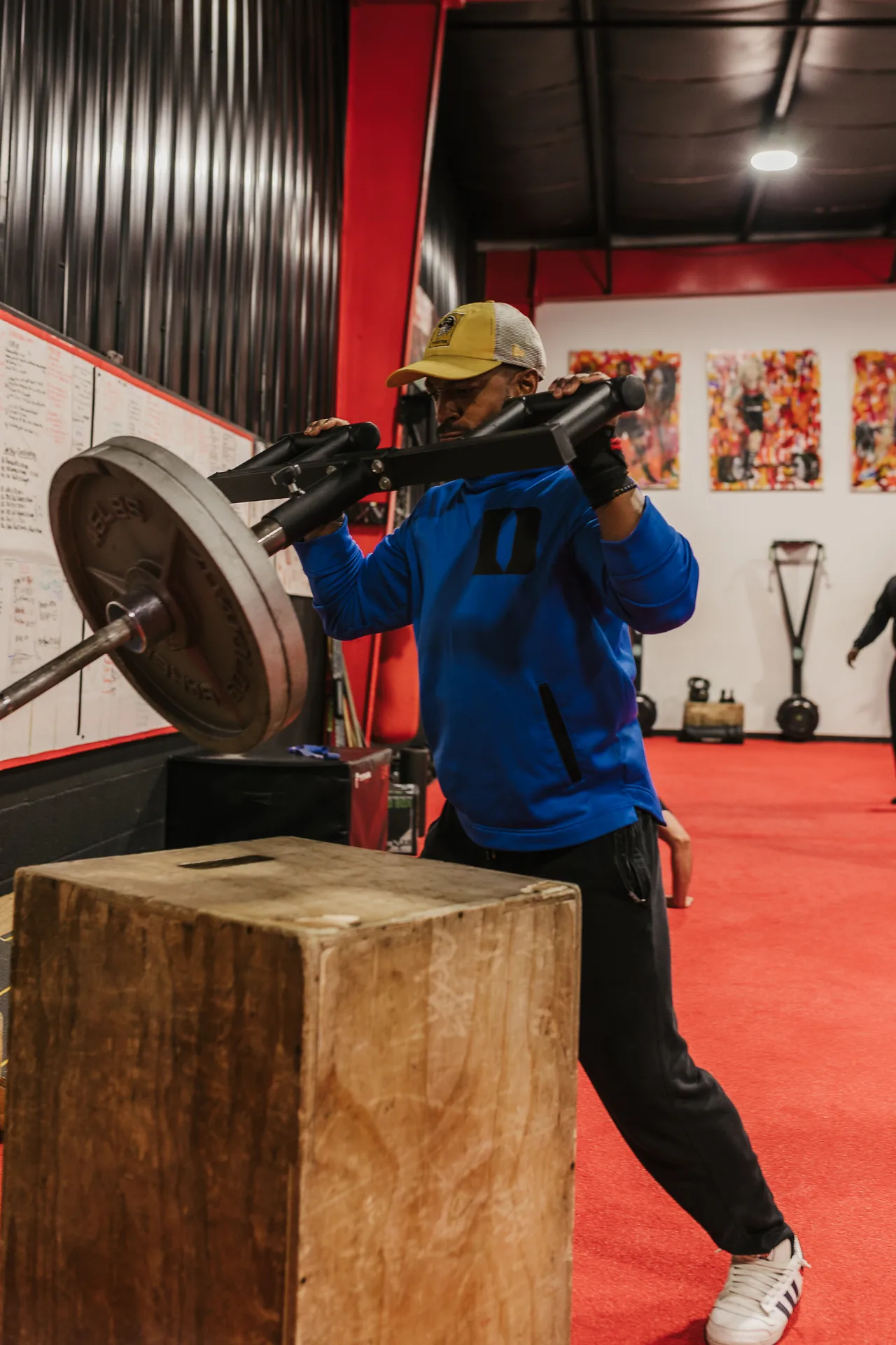 A coach spotting a member through a heavy lift