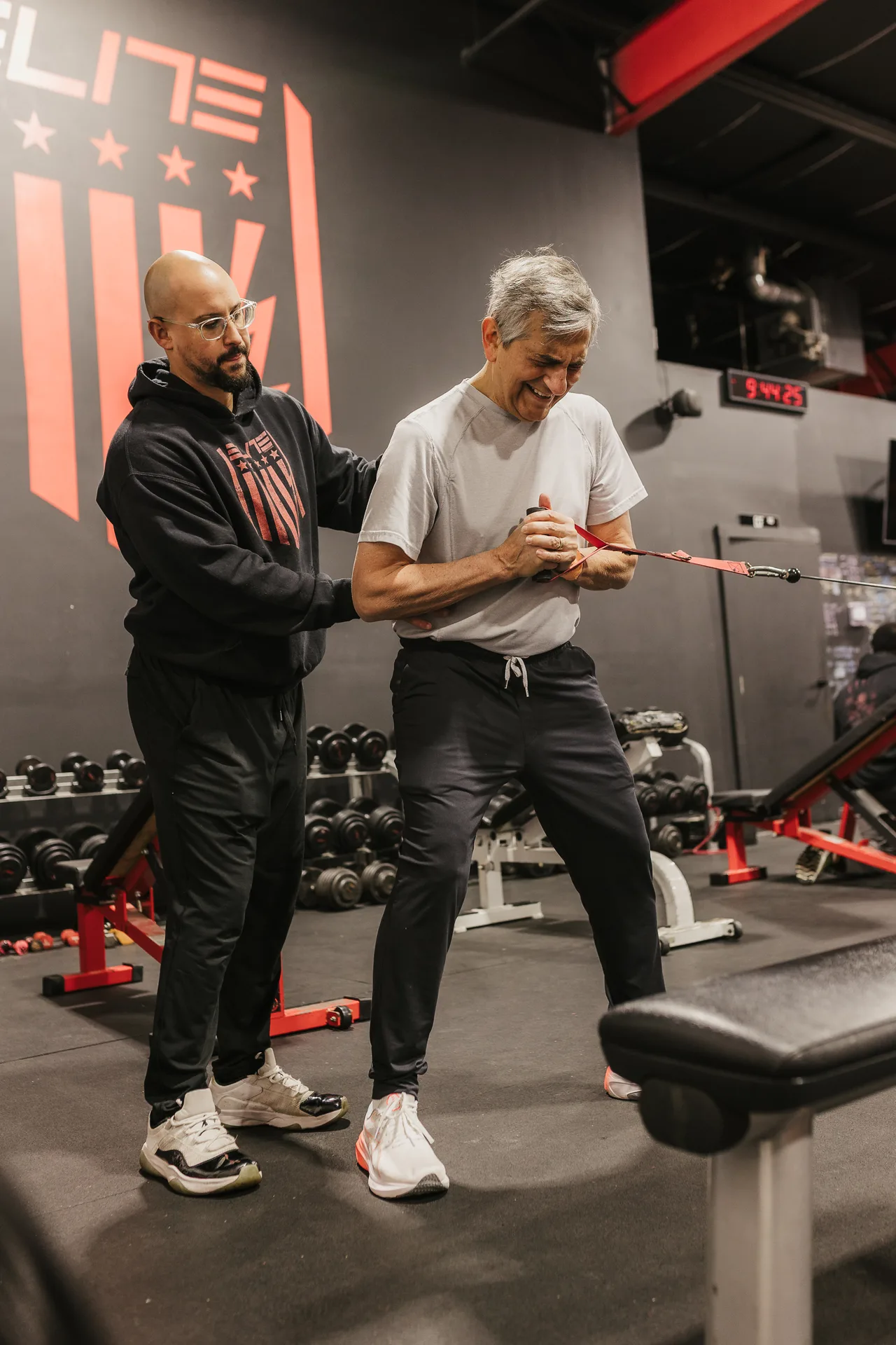An Elite Custom Fitness coach guiding a member through a training session